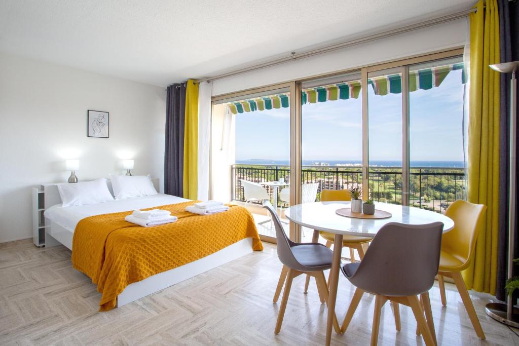 a hotel room with a bed and a table and chairs at Cannes Marina suite vue mer in Mandelieu-La Napoule