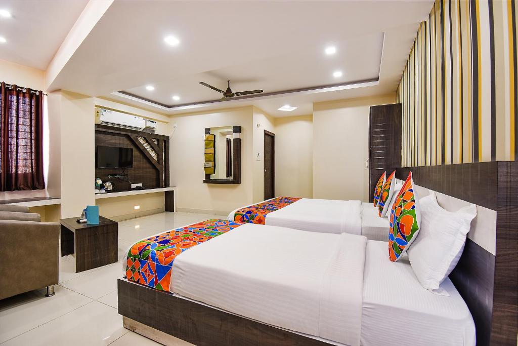 una camera da letto con due letti e un soggiorno di FabHotel Rotano Suites - Yelahanka a Bangalore