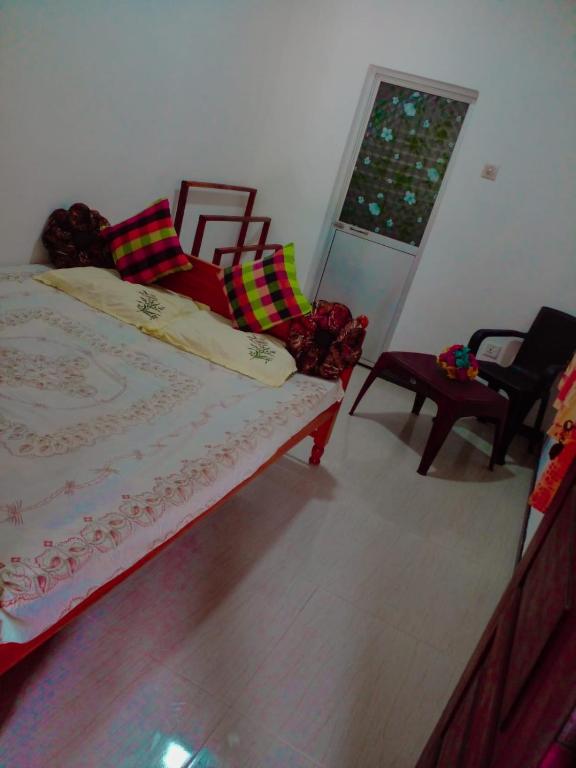 a bedroom with a bed and two chairs and a window at Shan Villa in Bentota