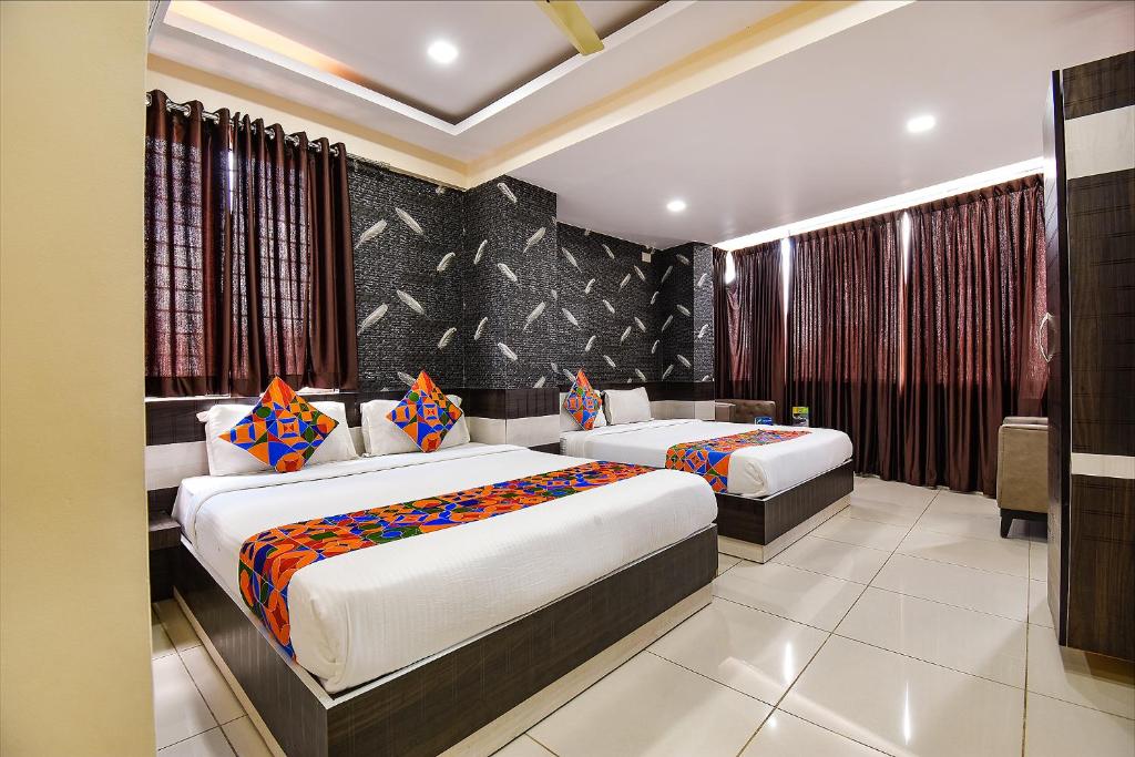 una camera da letto con due letti in una stanza di FabHotel Rotano Suites - Yelahanka a Bangalore