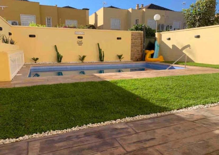 a backyard with a swimming pool in a yard at CASA DE LUJO CON PISCINA a 5 minutos andando del recinto ferial in Jerez de la Frontera