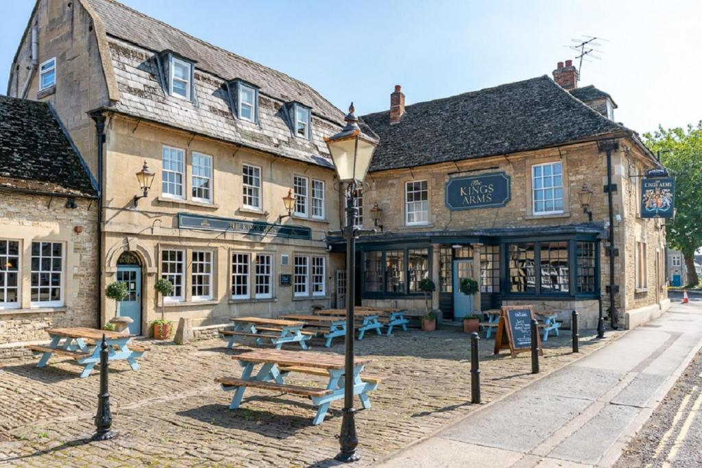 um edifício com mesas de piquenique em frente em The Kings Arms Hotel em Melksham