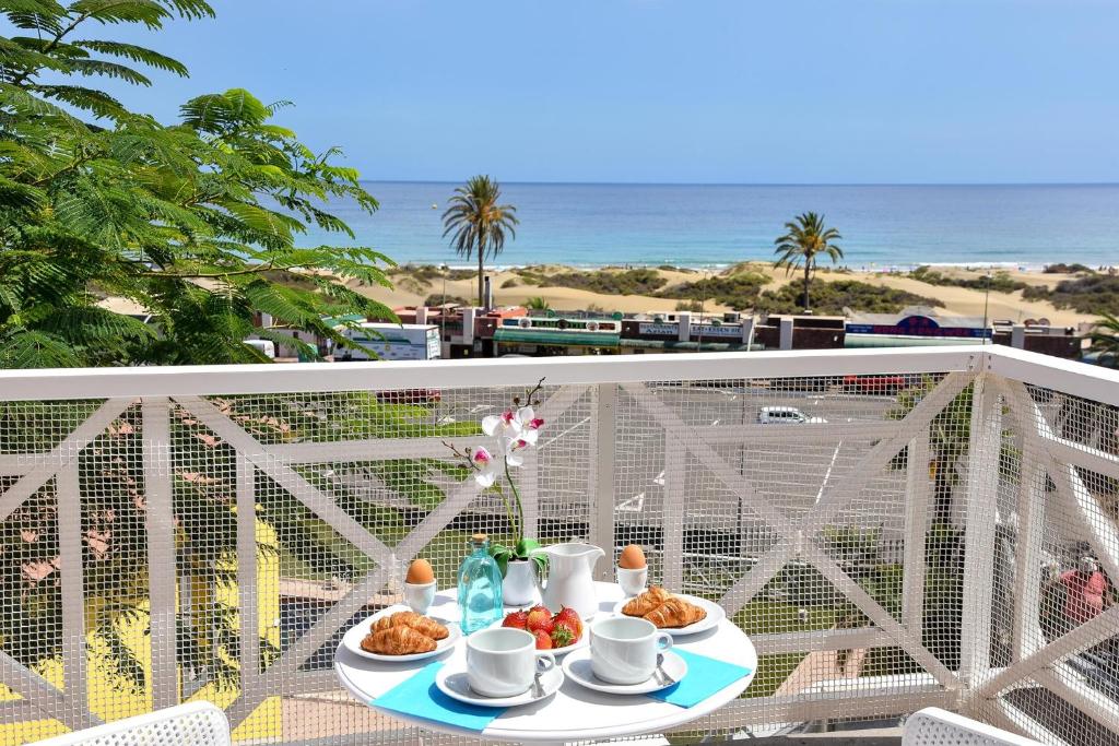 un tavolo con cibo su un balcone con vista sulla spiaggia di Chalet Santa Ana 7 by VillaGranCanaria a Playa del Ingles