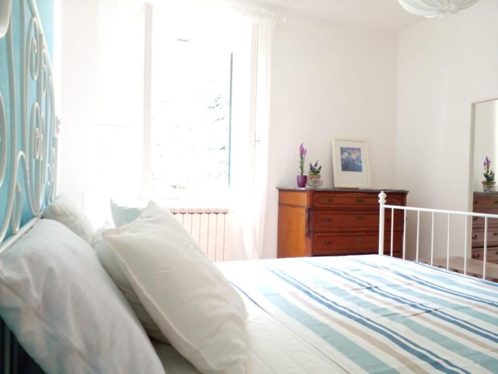 a bedroom with a bed with white pillows and a window at CASA ADRI. Comoda, accessibile, luminosa. in Vernazza