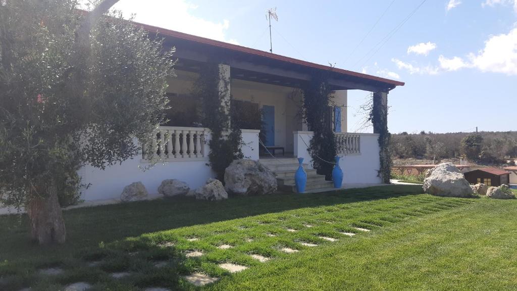 a white house with a yard with rocks at Mariam Holiday House in Otranto
