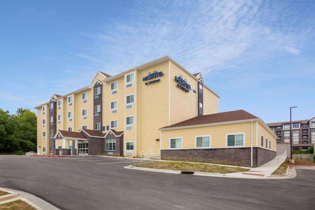 a large hotel with a parking lot in front of it at Microtel Inn & Suites by Wyndham Liberty NE Kansas City Area in Liberty