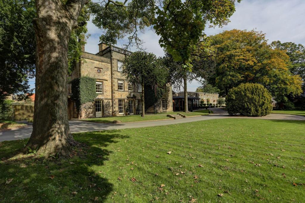 una vieja casa de piedra con un árbol en primer plano en Best Western Plus Sheffield Mosborough Hall Hotel, en Sheffield