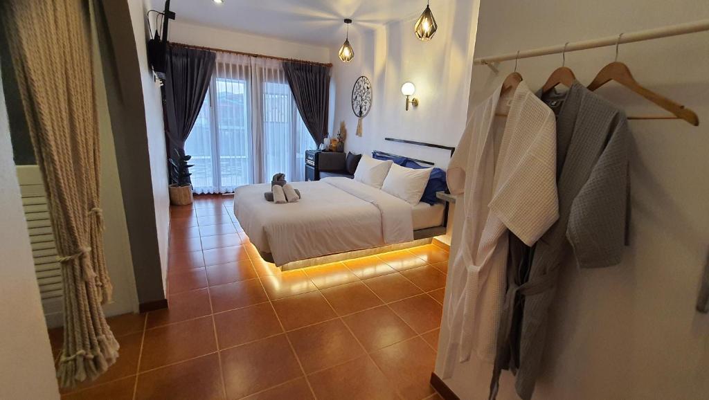 a hotel room with a bed and a robe on a wall at บ้านมัจฉา in Ko Larn