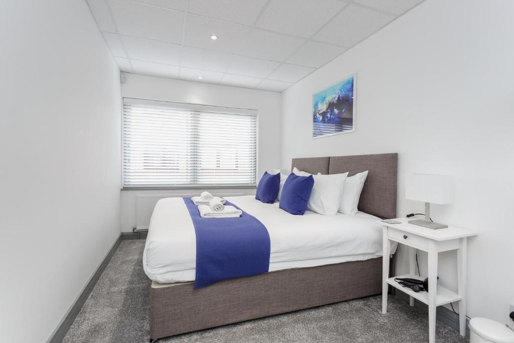 a bedroom with a large bed with blue pillows at Sovereign Gate 2 - 2 bedroom apartment in Portsmouth City Centre in Portsmouth