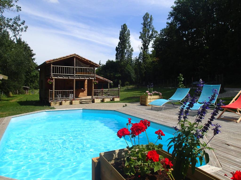 a swimming pool with a gazebo and some flowers at Le chalet de Cavailla in Marmont-Pachas
