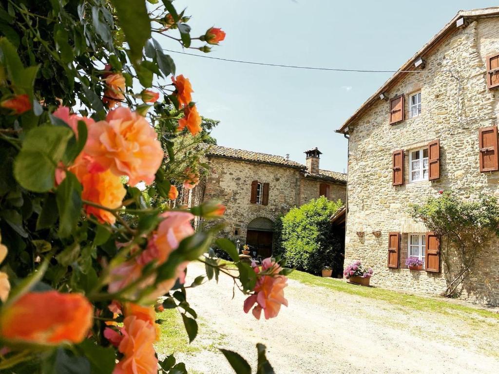 ein altes Steingebäude mit Blumen davor in der Unterkunft Cammino Nel Verde in Fornovo di Taro