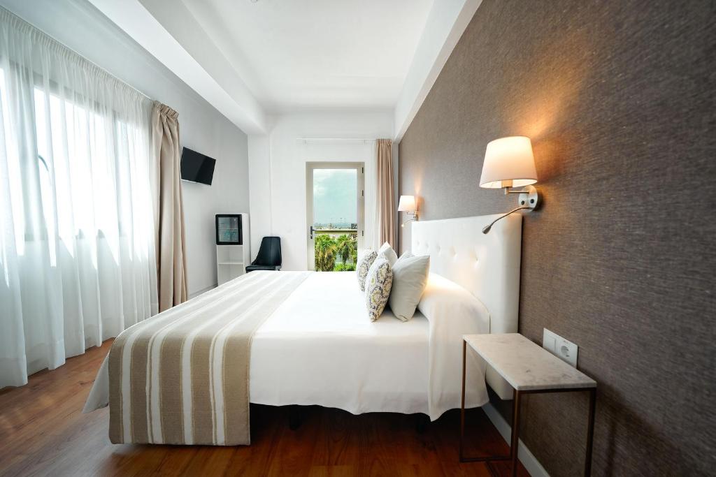 Un dormitorio con una gran cama blanca y una ventana en Hotel Matilde by Grupo Matilde, en Las Palmas de Gran Canaria