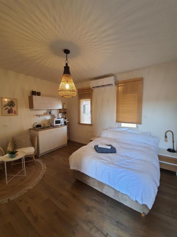 1 Schlafzimmer mit einem großen weißen Bett und einer Küche in der Unterkunft חדר במדבר in Beʼer Ora