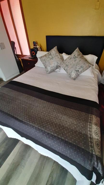uma cama com almofadas num quarto em Orkkowasi backpackers em Arequipa