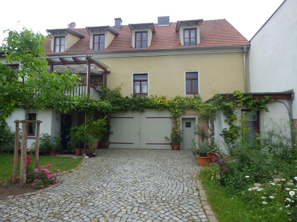 a house with a driveway and a garage at Ferienwohnung Högel Großjena in Naumburg