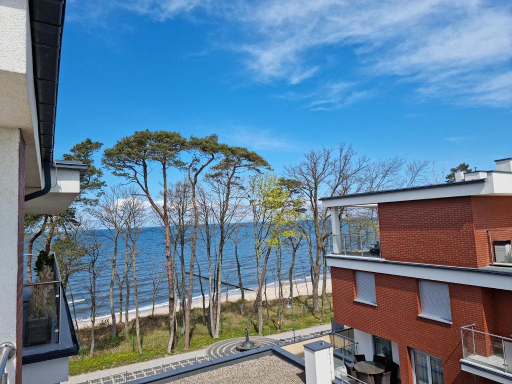 a view of the beach from the balcony of a building at Zielony Domek Apartament w Rewalu 42 m2, tylko 40 metrów od plaży in Rewal