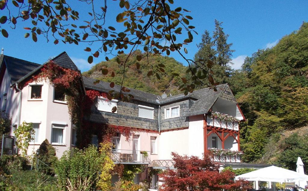 ein großes Haus auf einem Hügel mit Bäumen in der Unterkunft Hotel Winneburg in Cochem