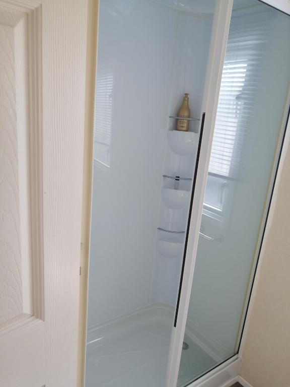 a glass walk in shower in a bathroom at La Chanterie Agréable Mobil-Home Résidentiel Normand in Saint-Pair-sur-Mer