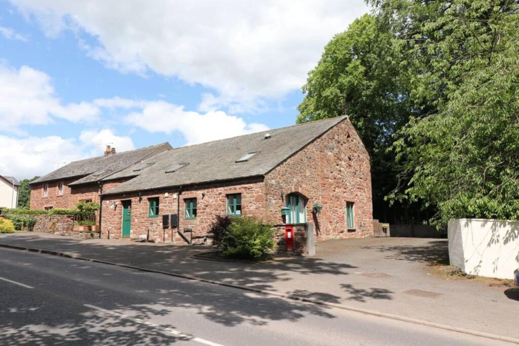 1 Friary Cottages, Appleby-in-Westmorland في أبليبي: مبنى من الطوب القديم على جانب شارع