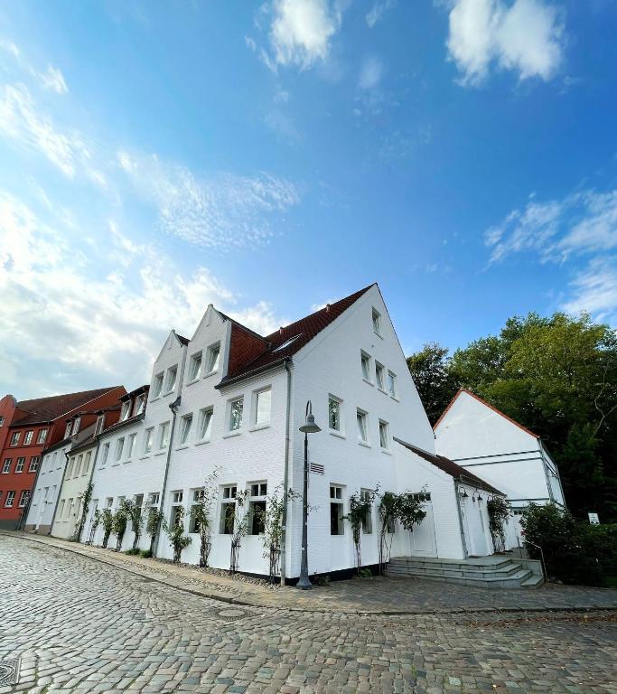 Un gran edificio blanco al costado de una calle. en Hotel Xenia Flensburg, en Flensburg