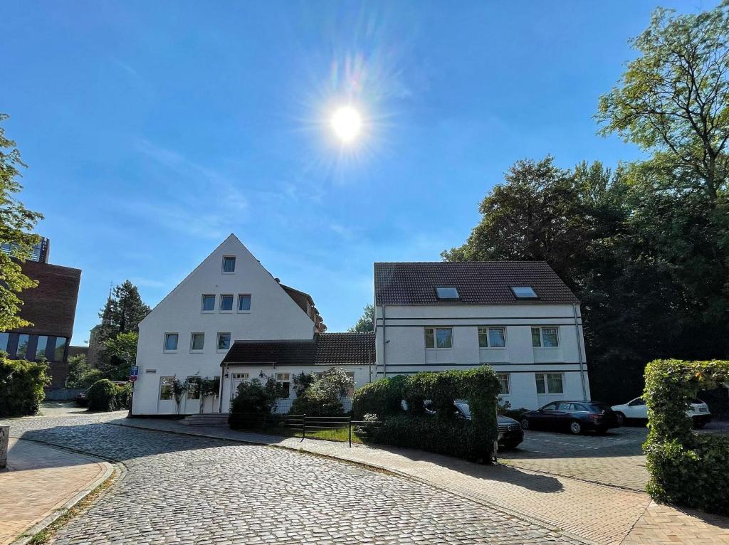 una casa blanca con el sol en el cielo en Hotel Xenia Flensburg, en Flensburg