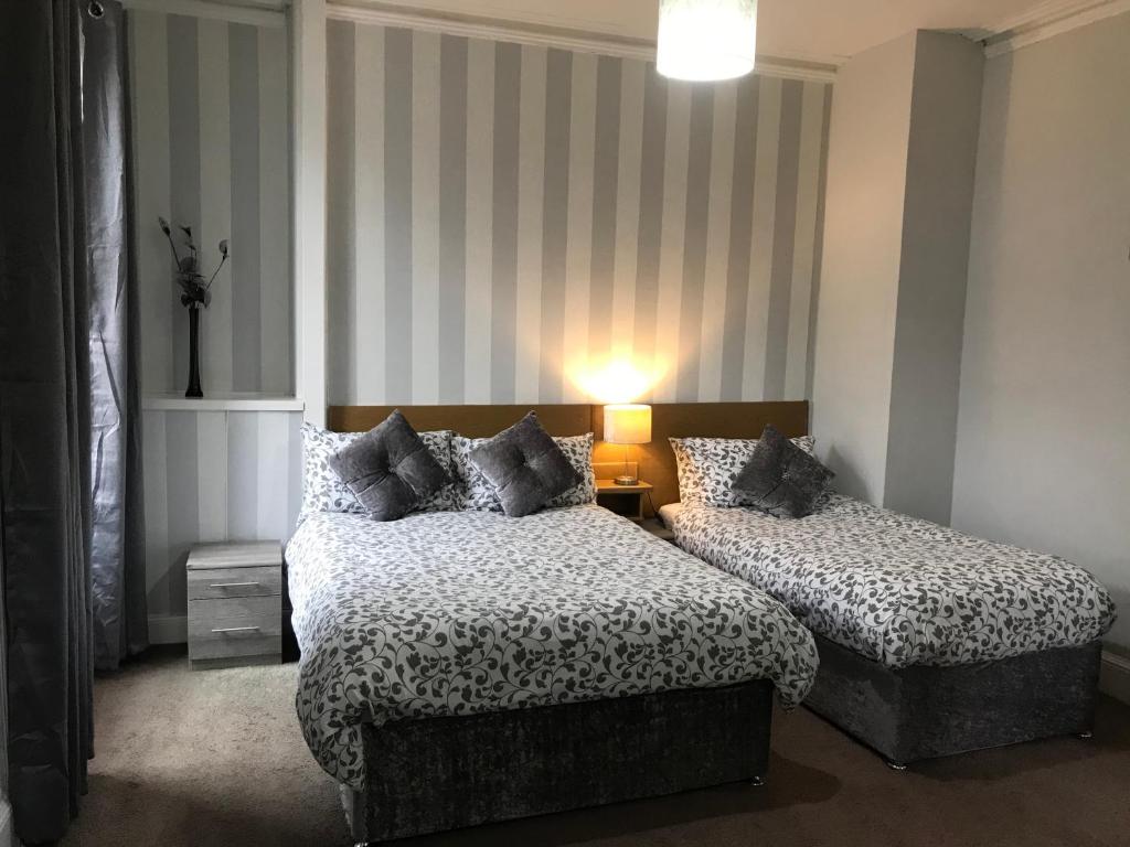 una habitación de hotel con 2 camas y una lámpara en DunMoore Guesthouse, en Oban