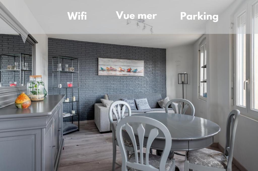 a kitchen and living room with a table and chairs at Appartement près du port centre et plage - Vue mer in Courseulles-sur-Mer