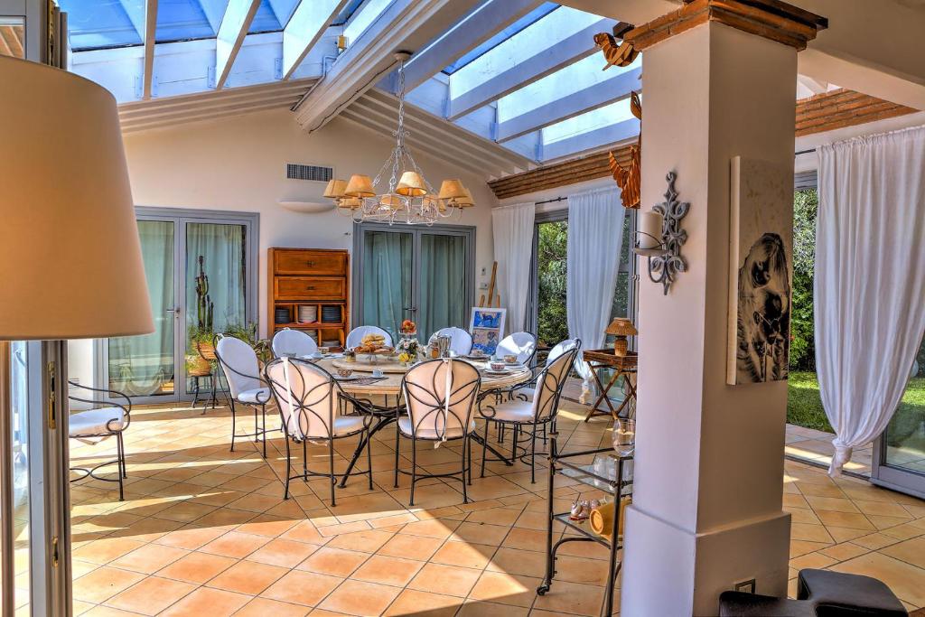 a dining room with a table and chairs and a glass ceiling at Villa Le Cave 12, Emma Villas in La Caduta