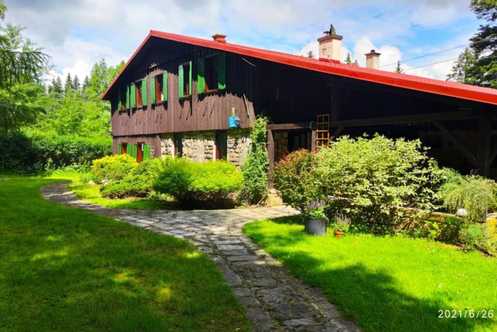 a barn with a red roof and a stone path at Chata Kataryniarza in Karłów