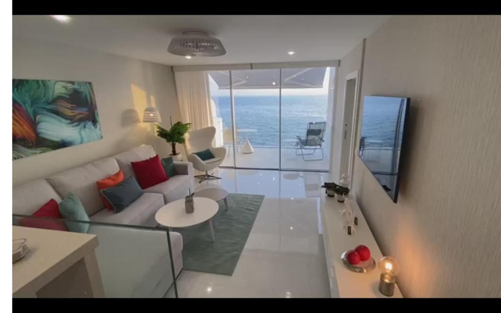 a living room with a couch and a view of the ocean at ocean experience / EXPERIENCE HOLIDAYS TENERIFE in Callao Salvaje