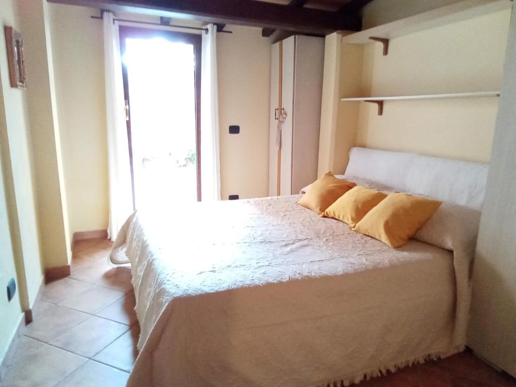 Un dormitorio con una cama con almohadas amarillas. en La bouganville, en Passoscuro