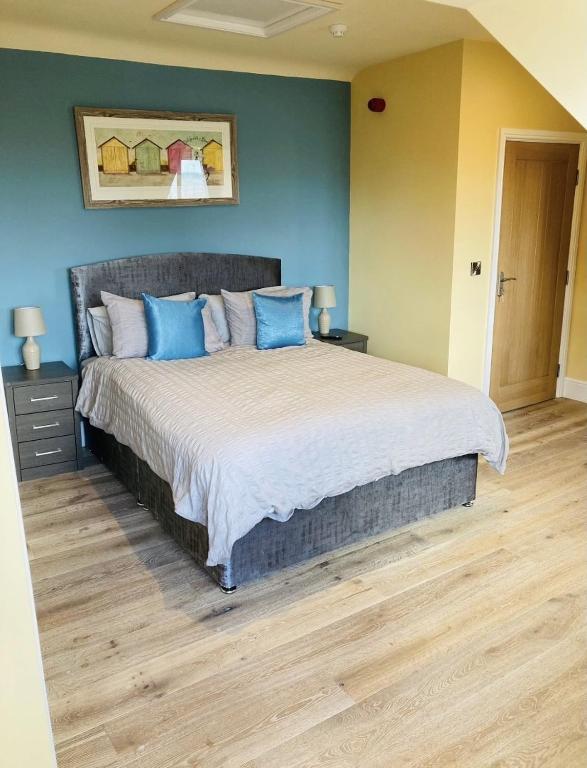 a bedroom with a large bed with blue pillows at Marine Boathouse View Apartment in Skegness