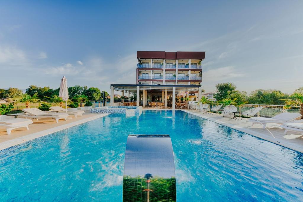 烏爾齊尼的住宿－獅子酒店，酒店游泳池的背景是一座建筑