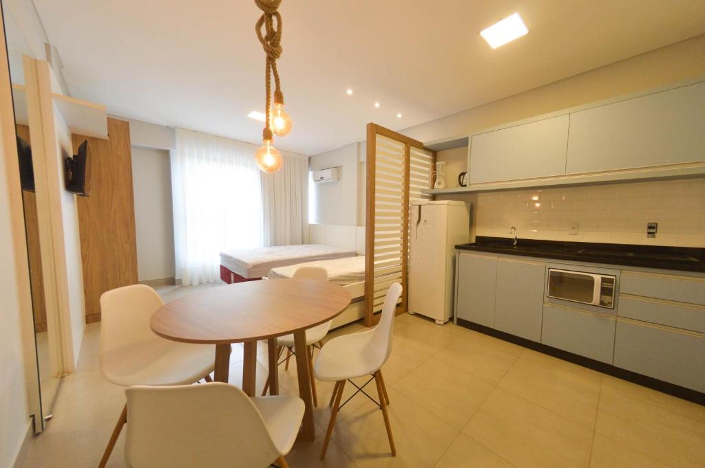 a kitchen and dining room with a table and chairs at RESIDENCIAL MAR BLUE in Bombinhas