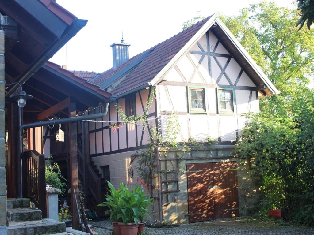 ein Haus mit einem Gamer-Dach und einer Garage in der Unterkunft Ferienwohnung Koppelblick in Pfarrweisach