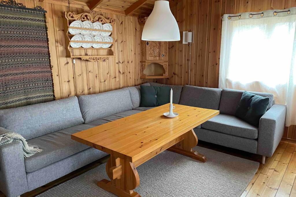a living room with a couch and a wooden table at Charming Mountain Cabin in Oppdal