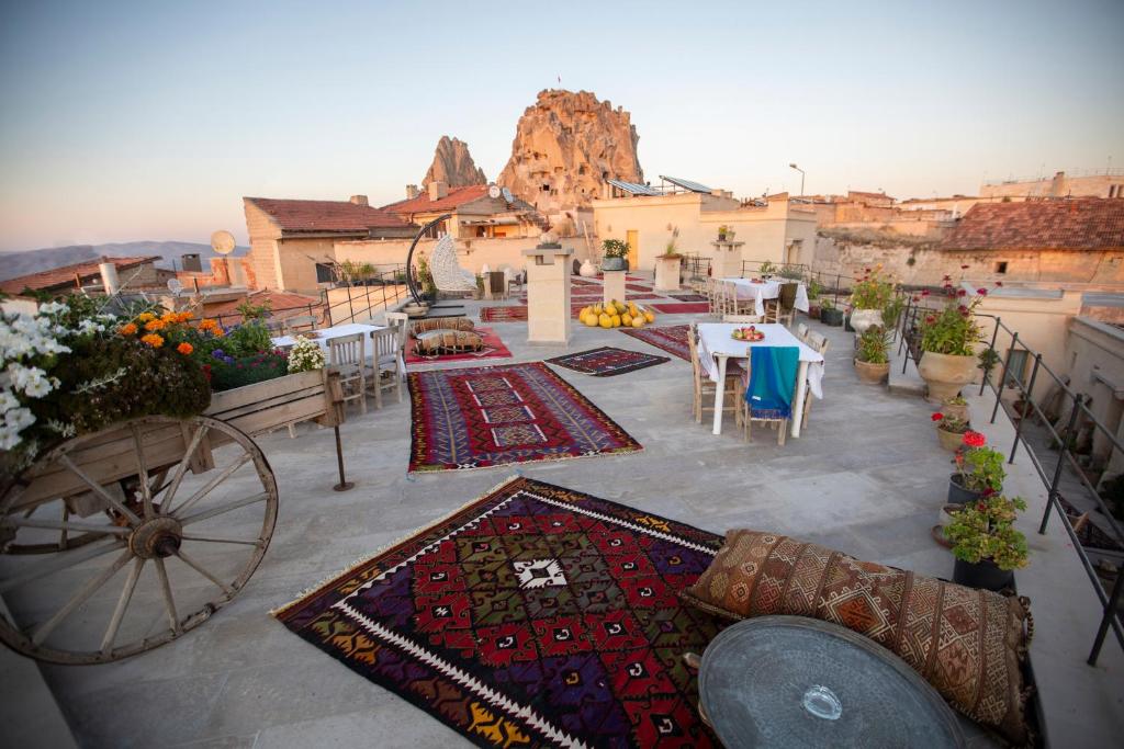 a balcony with a table and chairs and rugs at Maze Of Cappadocia Hotel in Uchisar