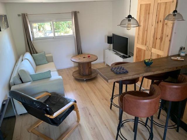 a living room with a couch and a table at Gite Mimosa in Saint-Florent-des-Bois