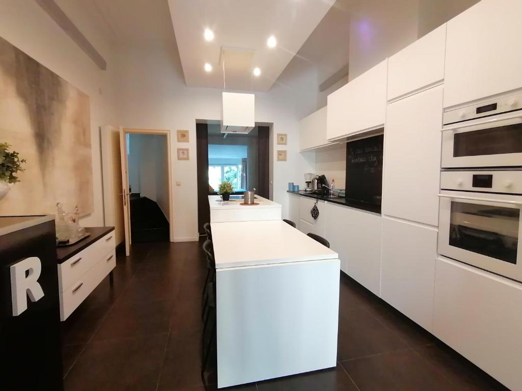 uma cozinha com armários brancos e um balcão branco em Brugmann Loft Apartment em Bruxelas