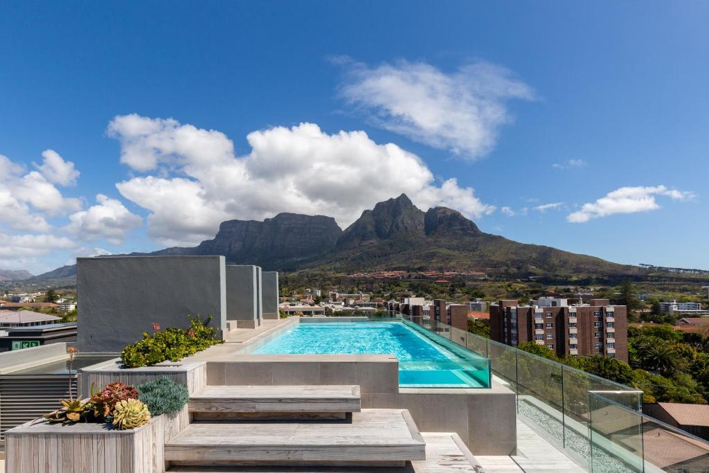 una piscina in cima a un edificio con montagna di Central Southern Suburbs Leafy Village Neighbourhood a Città del Capo