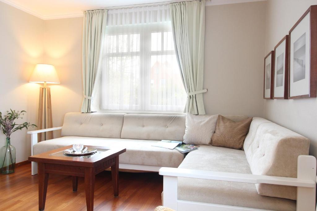 ein Wohnzimmer mit einem Sofa und einem Tisch in der Unterkunft Haus am Park Wohnung Nr6 in Spiekeroog