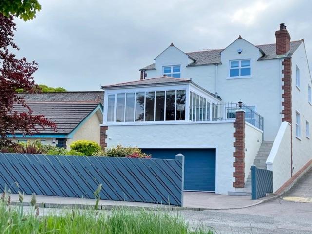 a large white house with a blue garage at The Cuan House in Strangford