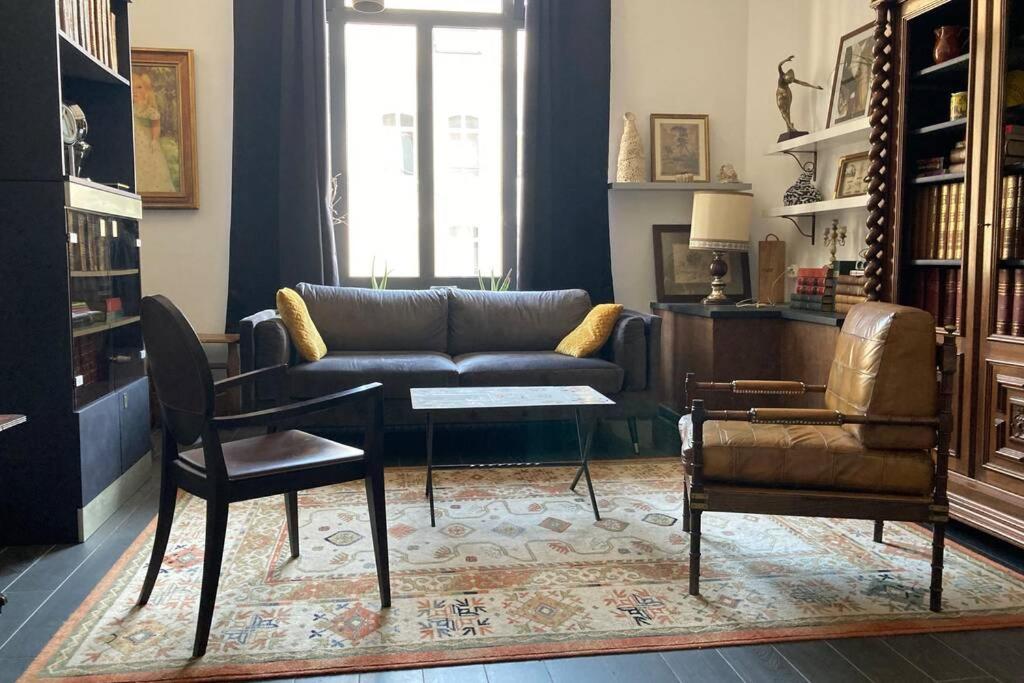 uma sala de estar com um sofá, uma mesa e cadeiras em Boulogne-sur-Mer : très bel appartement de charme em Boulogne-sur-Mer