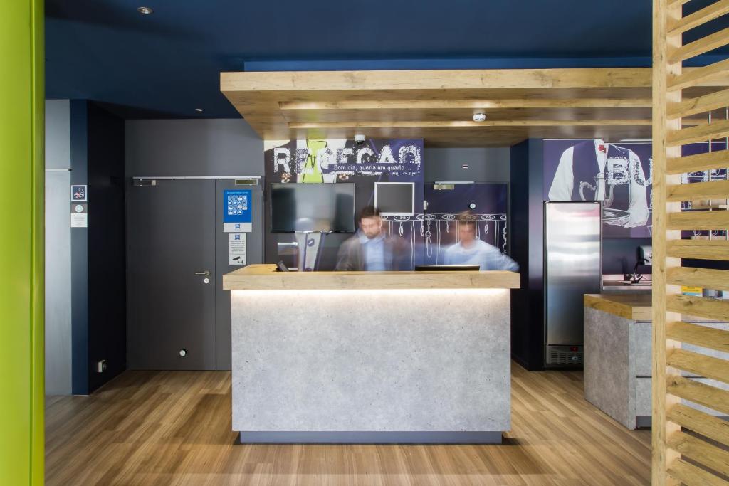 dos hombres parados en un mostrador en una cocina en Ibis Budget Braga Centro, en Braga