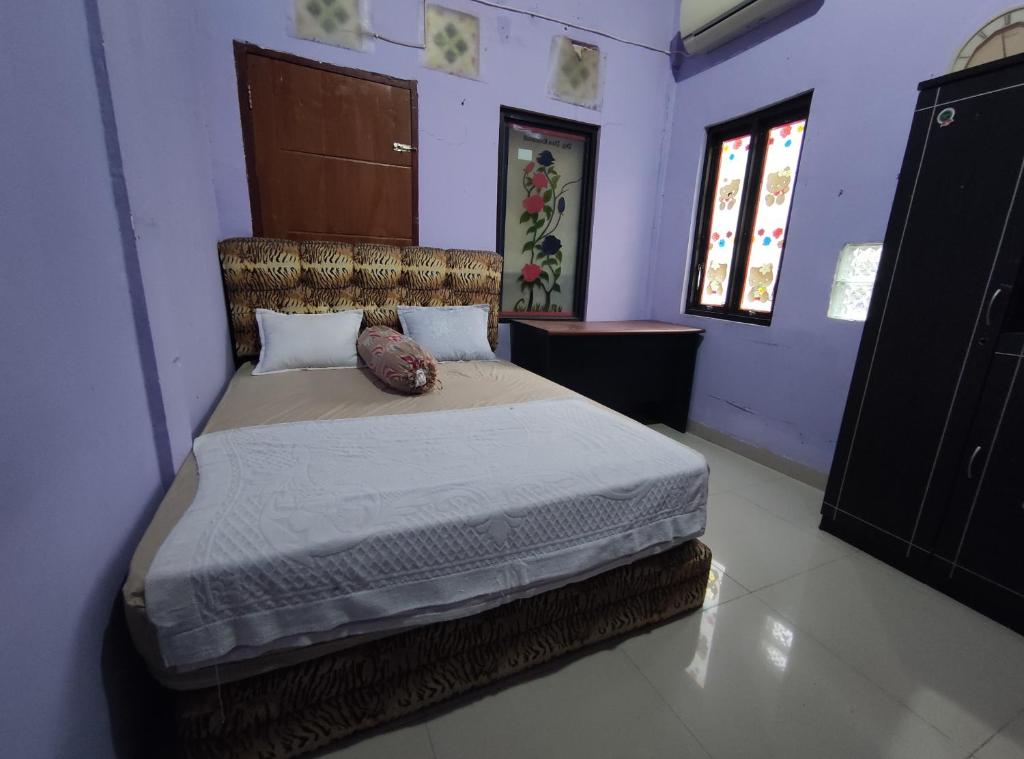 a bedroom with a large bed in a room at OYO 90633 Graha Dirham Homestay in Sekayu