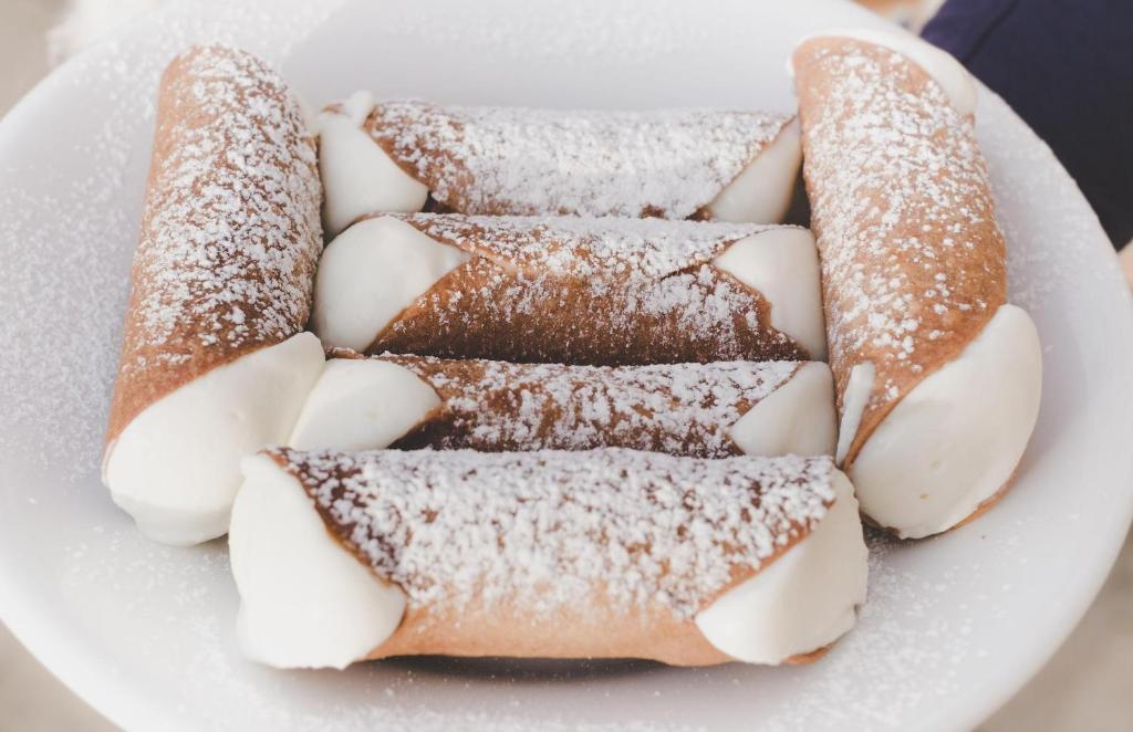 a plate of pastries with powdered sugar on it at Ursino's Luxury in Catania