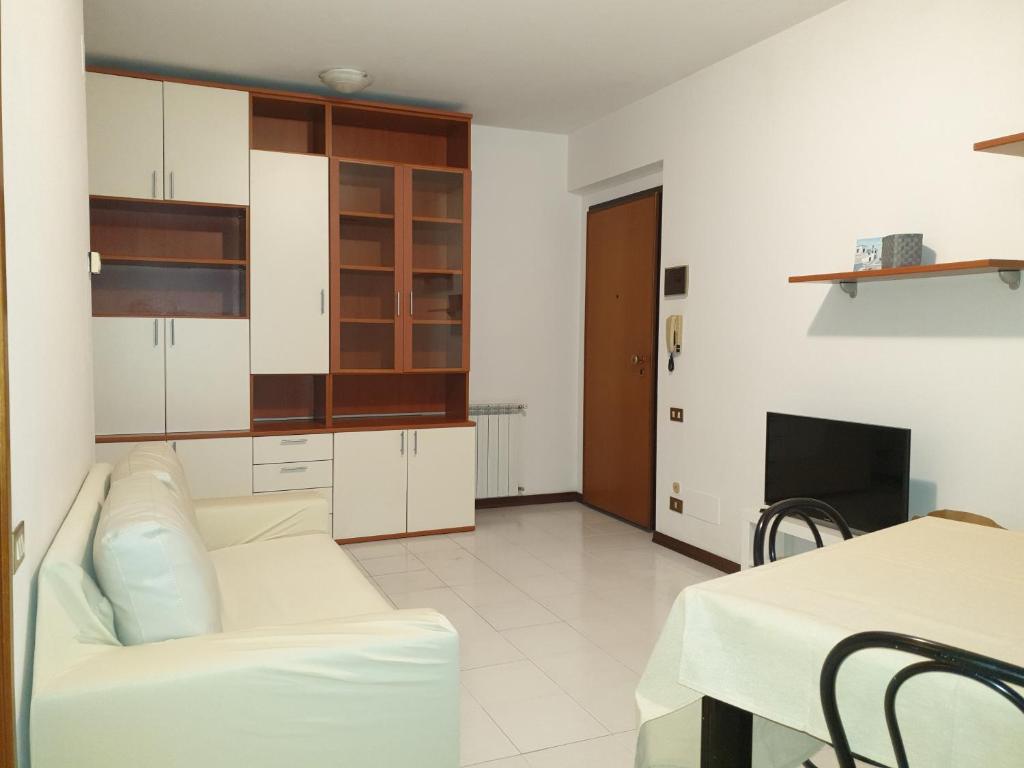een woonkamer met een witte bank en een tafel bij Appartamento ALICE (CISANELLO-PISA) in Pisa