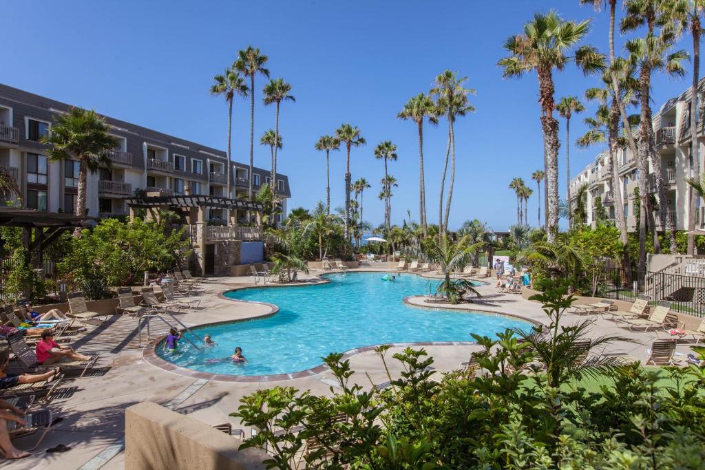 a swimming pool at a resort with palm trees at 3 Bedroom! - Complex is on the beach with huge pool in Oceanside