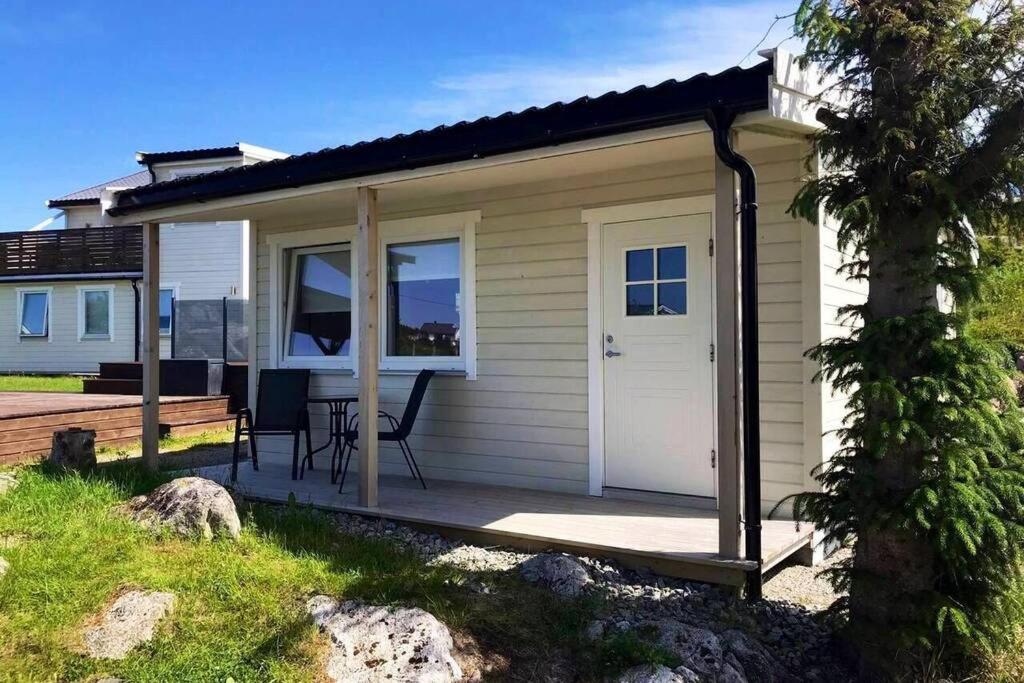 uma pequena casa com um alpendre e um deque em Feriehus med Sjøutsikt em Sætra
