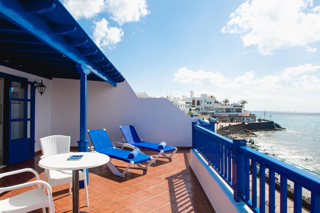 einen Balkon mit Stühlen, einem Tisch und Meerblick in der Unterkunft Blancazul Mingo Alto in Playa Blanca